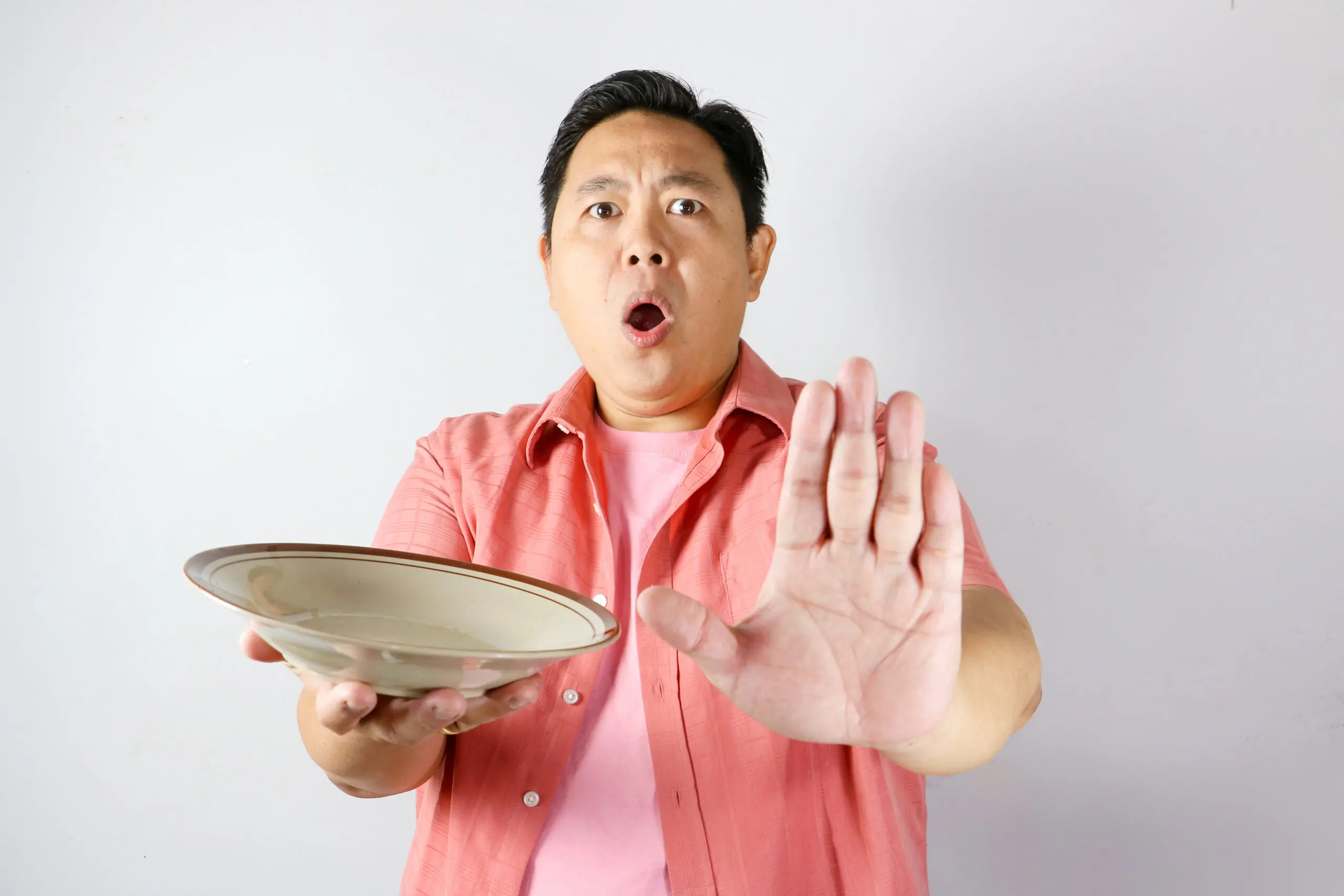 Surprised man holding an empty plate illustrating Reta no appetite